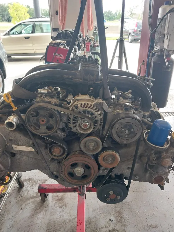 Engine pulled and hung on a hoist for repair